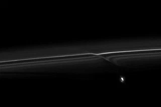 La lune Promethée et la perturbation quelle cause à lanneau F de Saturne. Image prise dans le visible à environ 950000 km de Saturne. (NASA/JPL/Space Science Institute)